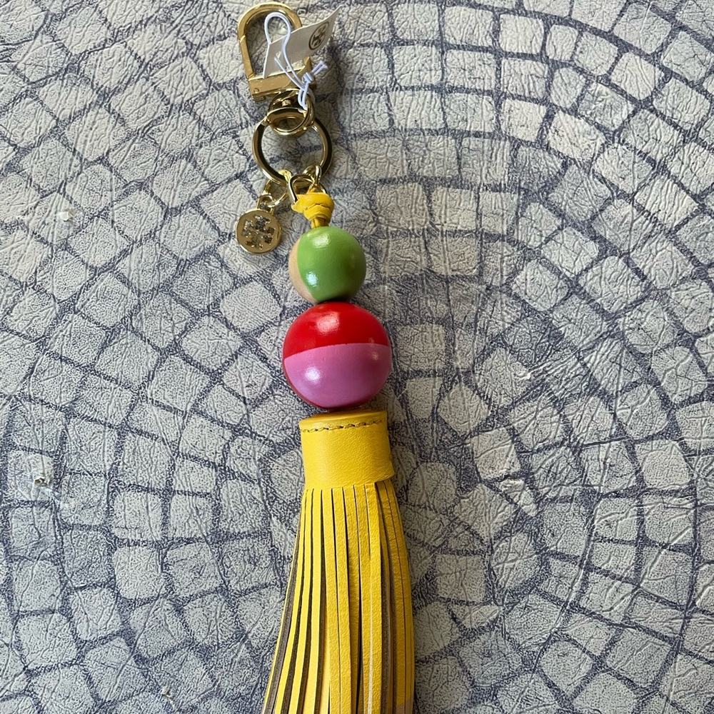 Brand new Tory Burch key fob. Colors: red, pink, yellow, green. Gold accents.
